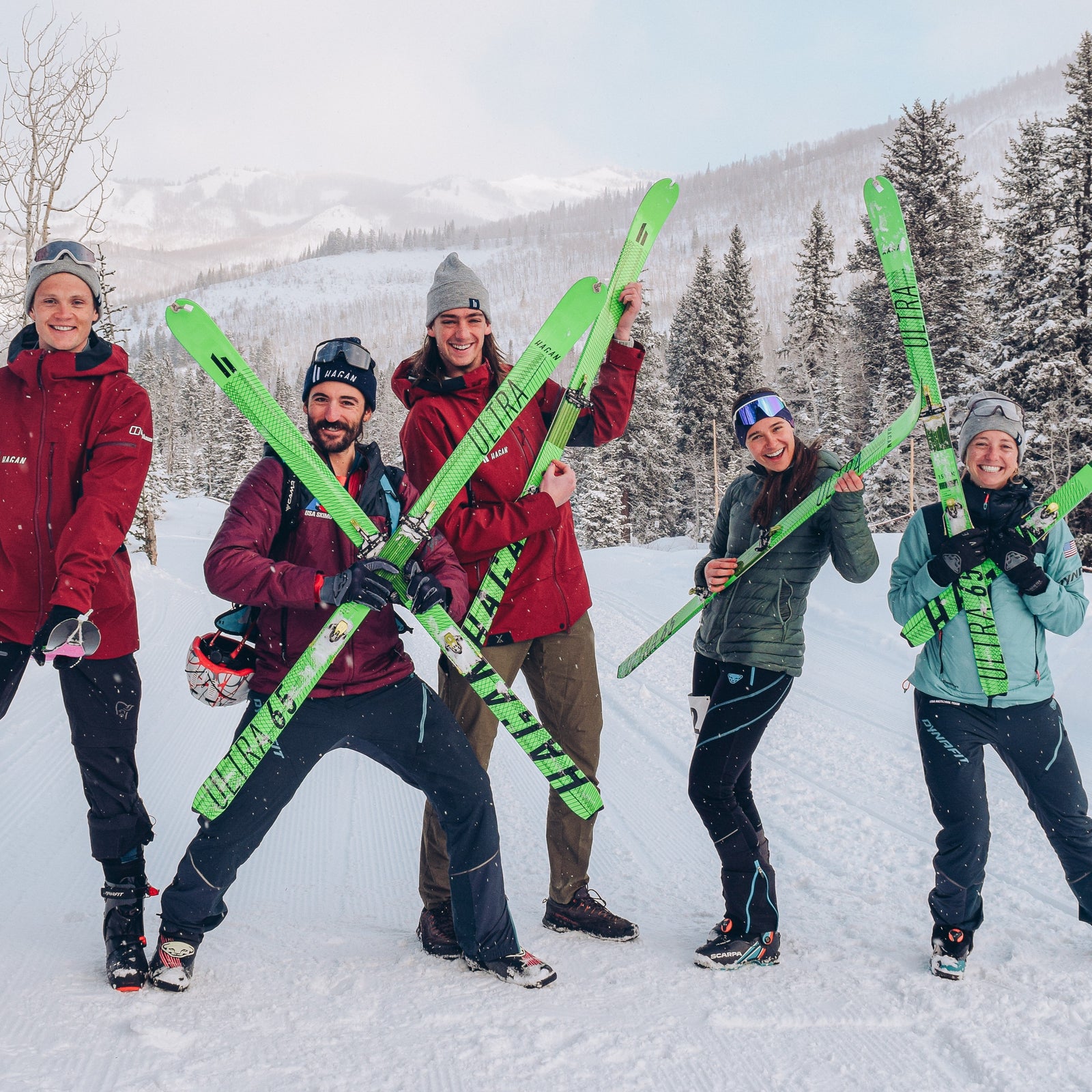Five HAGAN Athletes posing with their green Ultra 65 race skis. 